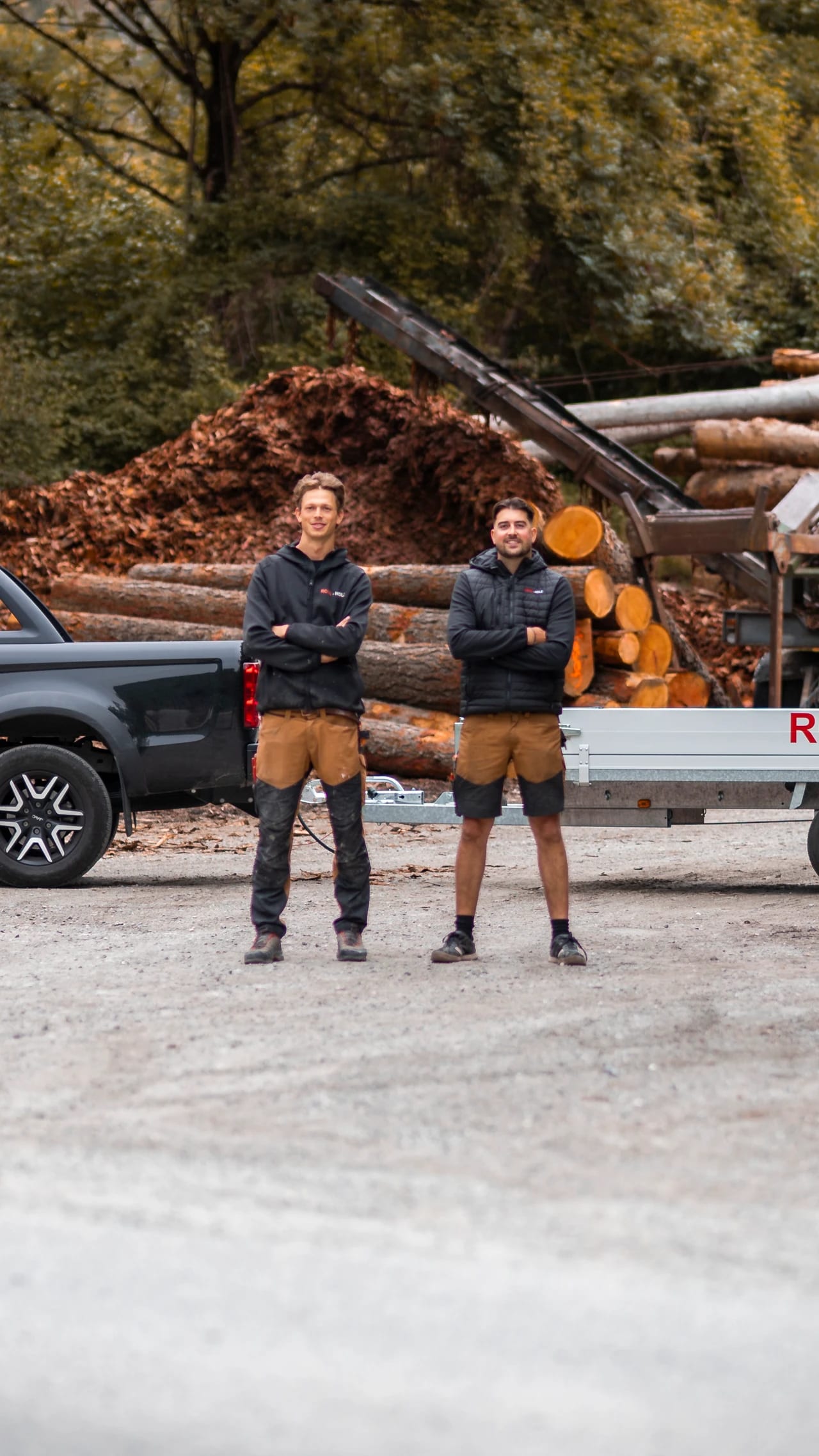 Valerio Obrist und Roy Wischnewski zwischen Pick-up und Anhänger von ROVA-HOLZ auf dem Holzplatz